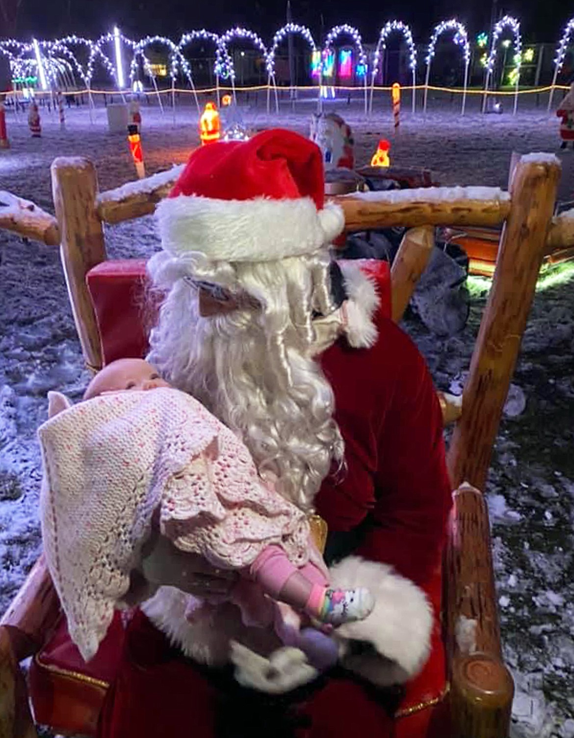 Santa Claus holds an infant at the holiday light show at Suntree RV Park.
