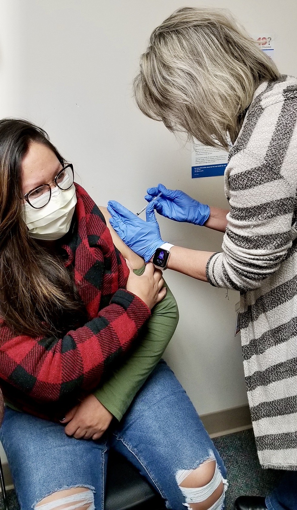 December: Nichole Moorhead, Kellogg Heritage Health RN, administers the latest Pfizer COVID-19 vaccine to customer service representative Rhonda Yazzi.