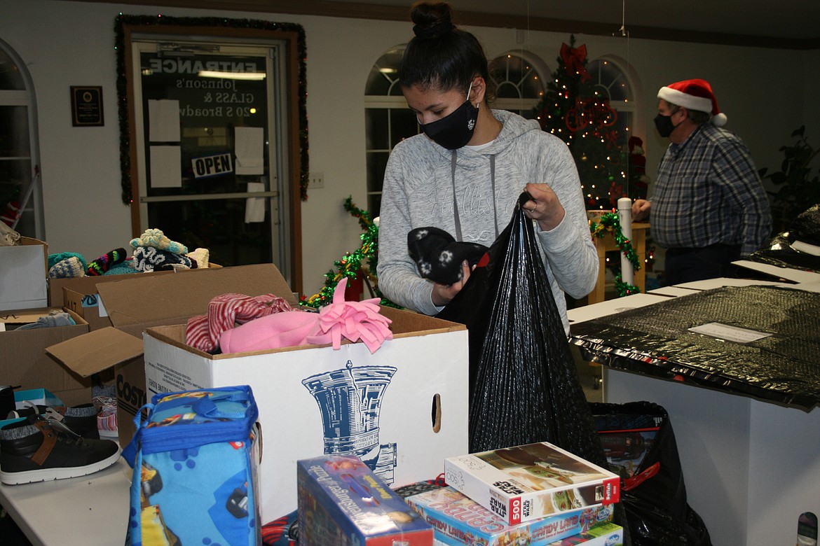 Anna Gonzalez picks out a winter hat for one of the recipients of toys through the Othello Christmas basket program.