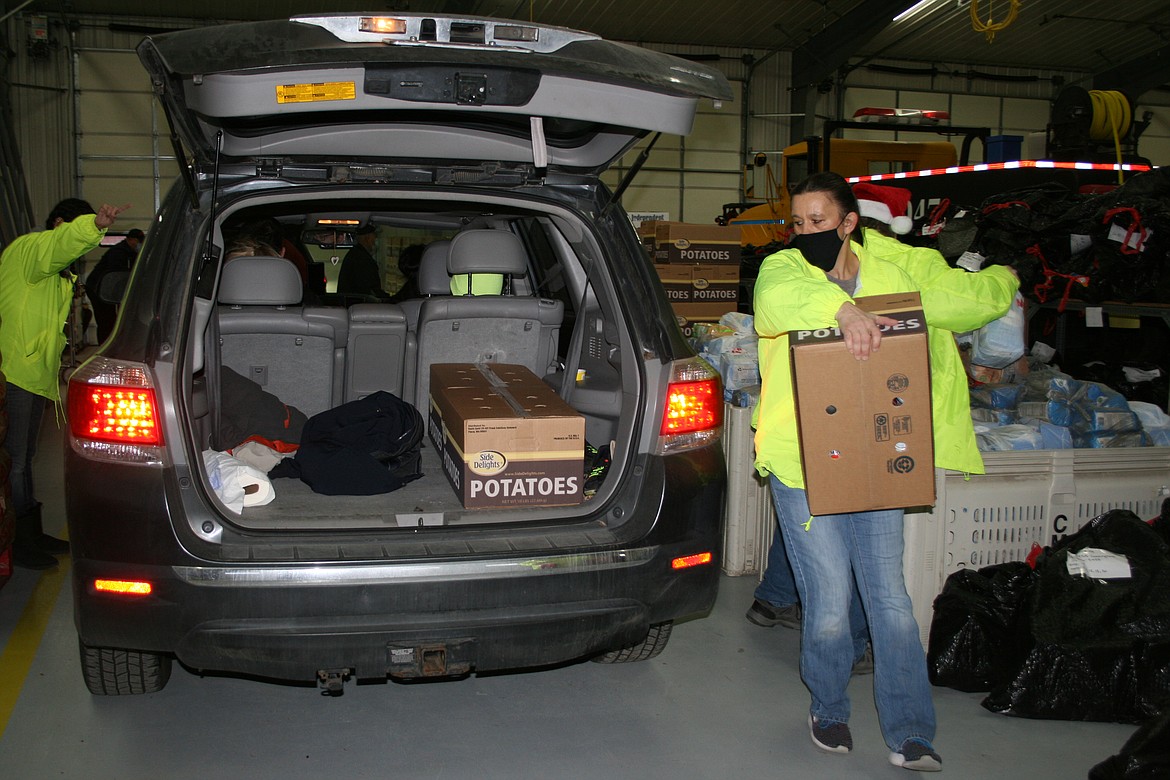 Dee Dee Duke loads a car with potatoes as part of the distribution of Christmas baskets in Othello Dec. 19.