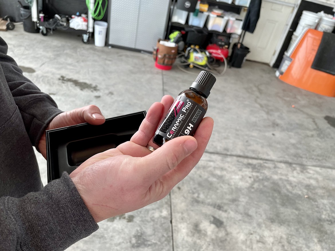 Tyler Hamberg shows off a 50 ml (around 1.7 liquid ounces) bottle of Ceramic Pro, the liquid ceramic coating he uses in his car and plane detailing business.