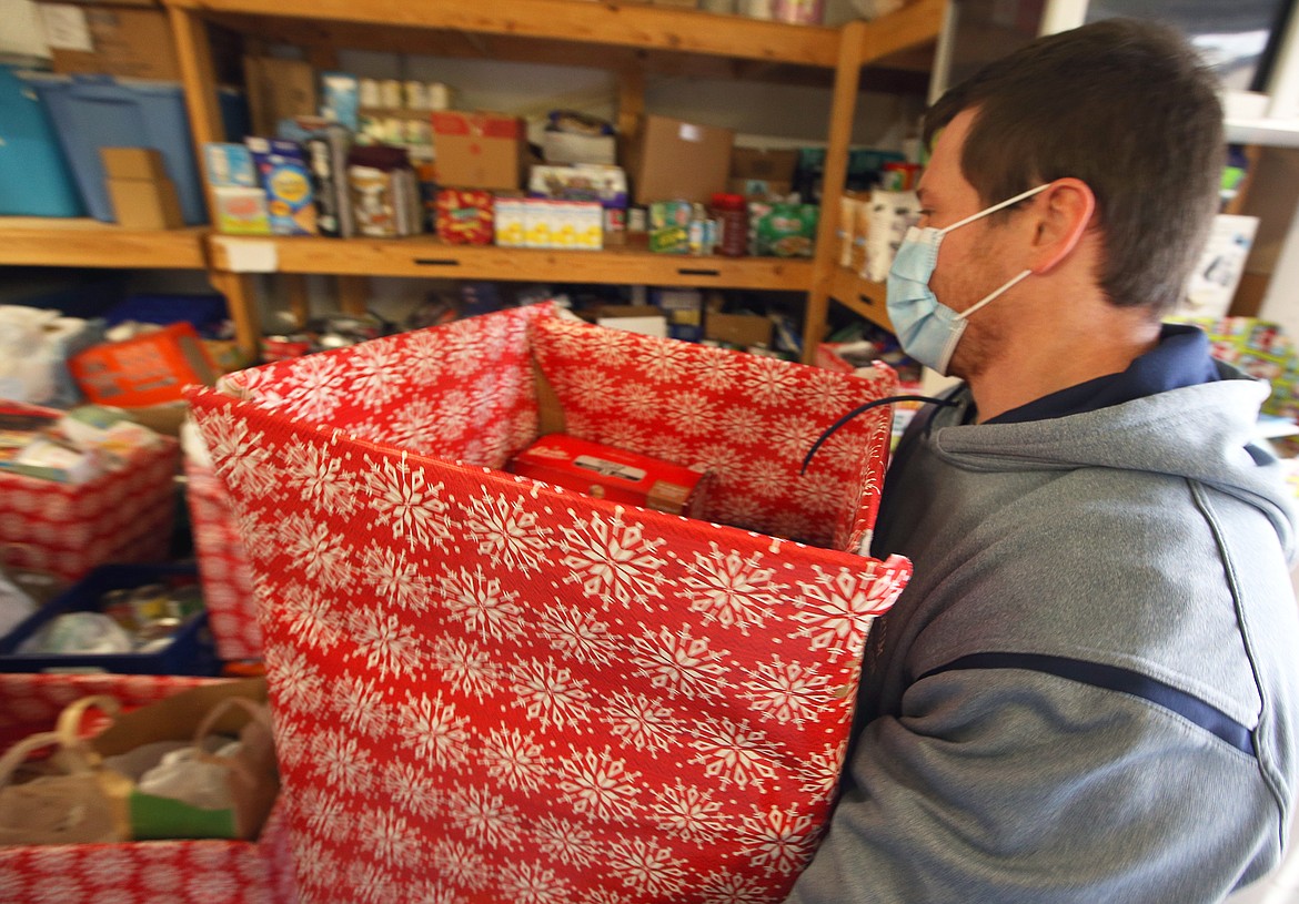 Mike Rouse with the City of Rathdrum Parks and Recreation carries a box of food into the Rathdrum Food Bank on Tuesday.