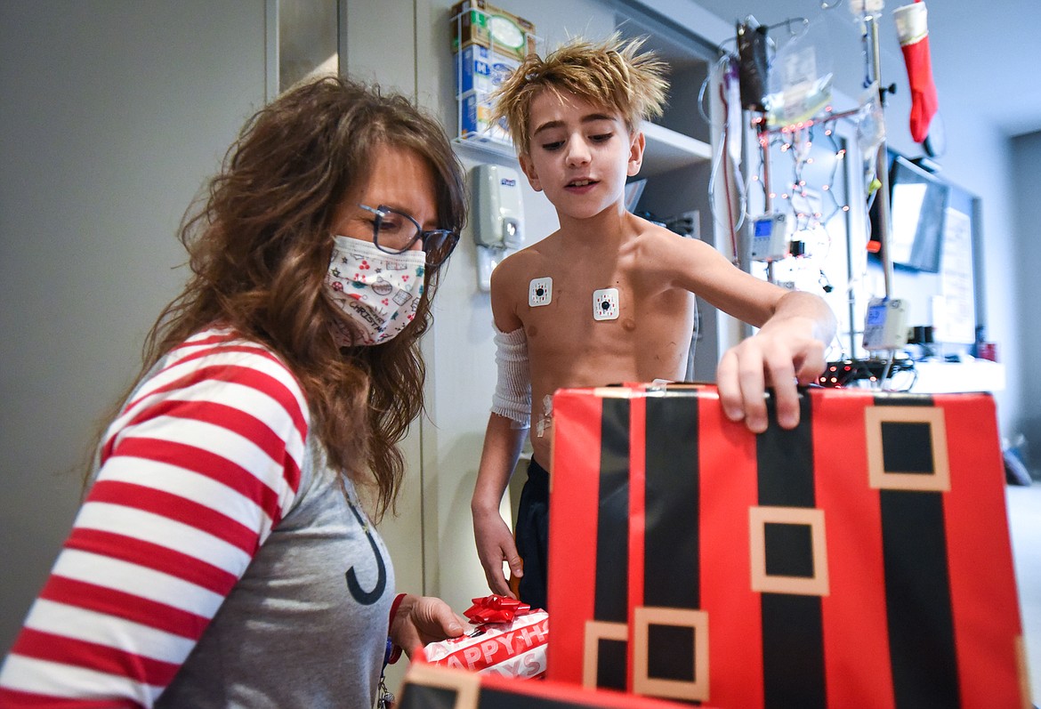 Coleman Lee, right, a patient in the pediatric wing at Montana Children's, looks through gifts for himself and his family with Amy Rohyans Stewart, Child Life Specialist and Coordinator with the hospital, on Wednesday, Dec. 23. Montana Children's is providing gifts to patients and their families through their Virtual Toy Drive during the holidays. (Casey Kreider/Daily Inter Lake)