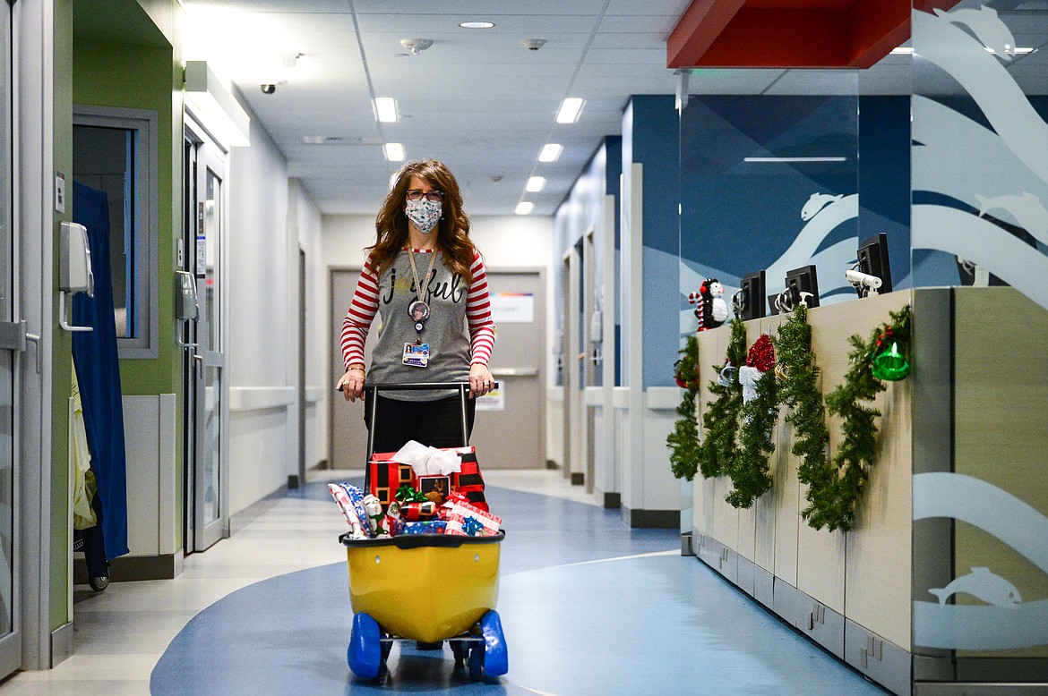 Amy Rohyans Stewart, Child Life Specialist Coordinator at Montana Children's, wheels a cart full of toys to the Lee family's room in the pediatric unit at the hospital on Wednesday, Dec. 23. Montana Children's is providing gifts to patients and their families through their Virtual Toy Drive during the holidays. (Casey Kreider/Daily Inter Lake)