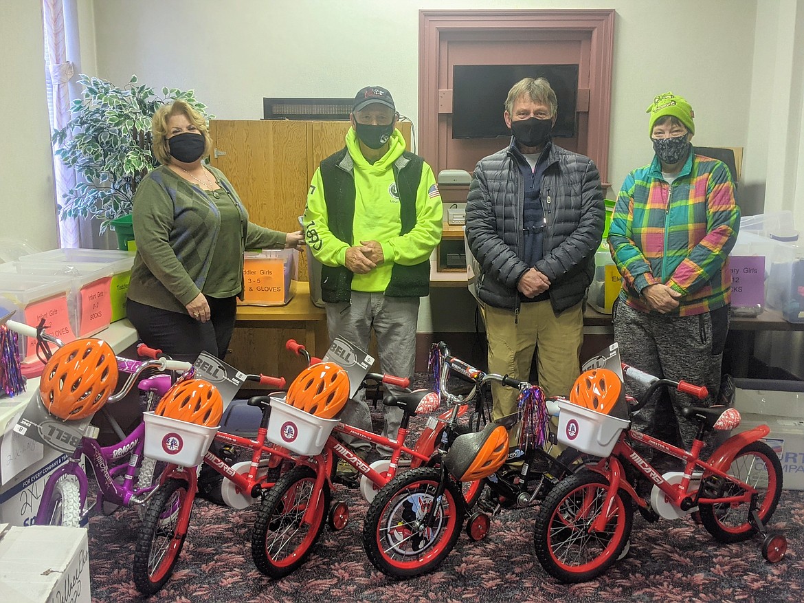 Jae Jean Achord, Joe Hauser, Mike Hauser, and Amy Lynn stand with the five bikes donated to the Wallace Christmas Fund.