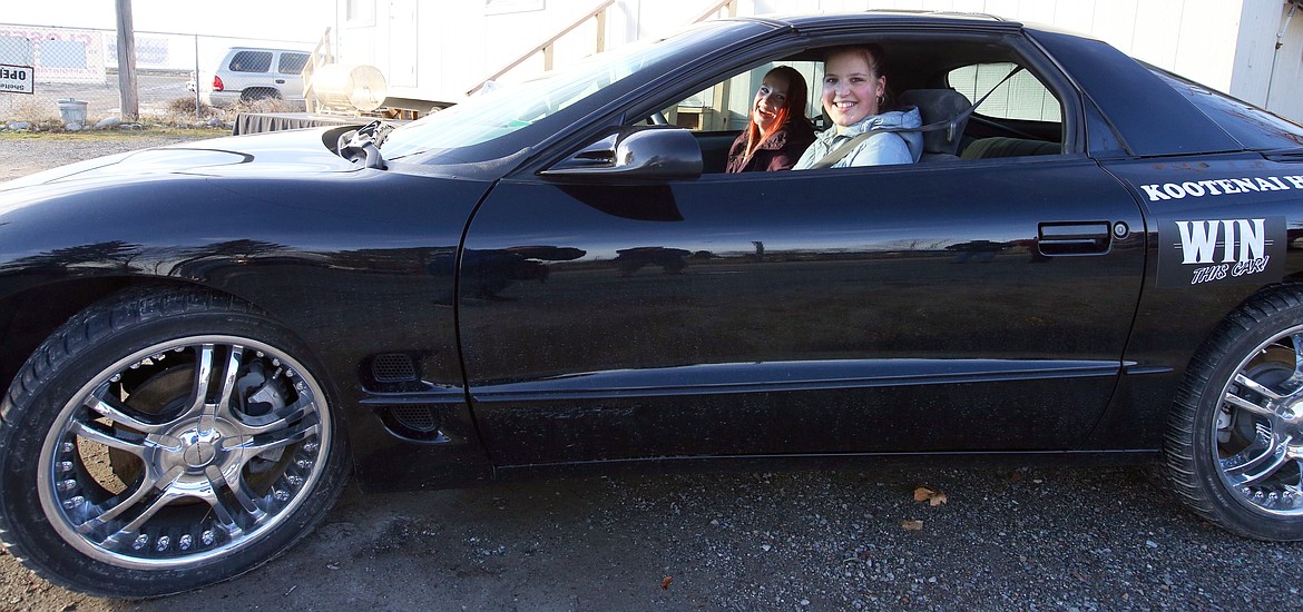 Bernie Bullington, with younger sister Mariana in the passenger seat, sits behind the wheel of the 1999 Pontiac Firebird she won in a drawing Wednesday to benefit the Kootenai Humane Society.