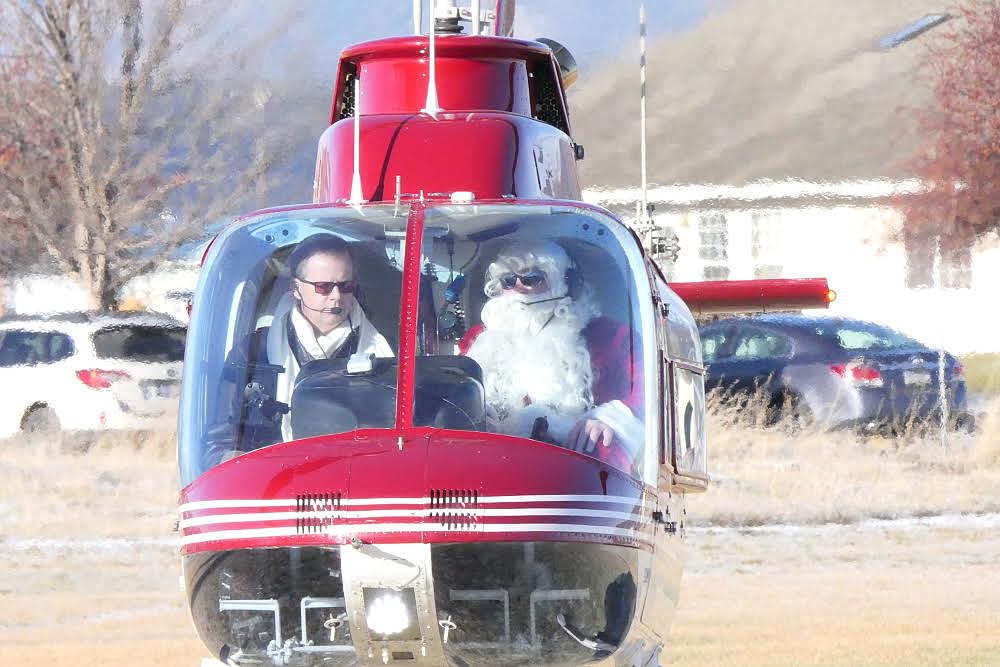 Pilot Art Dykstra, of Thompson Falls, arrives with Santa at the Plains High School landing site last week. (Chuck Bandel/Valley Press)