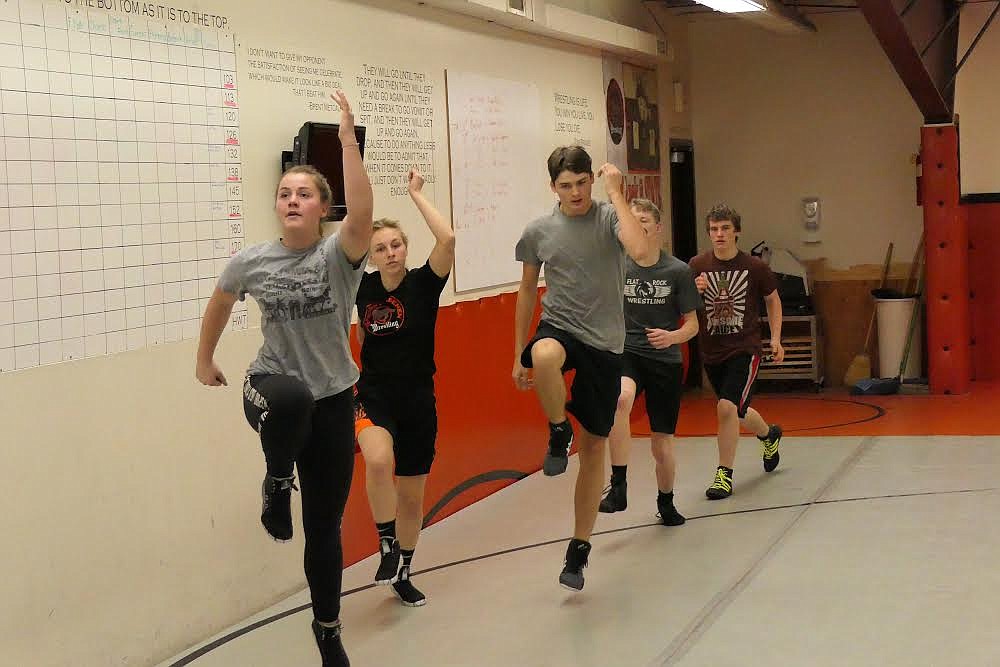 The Plains wrestling team does laps in the mat room during a warmup for a recent practice. (Chuck Bandel/Valley Press)