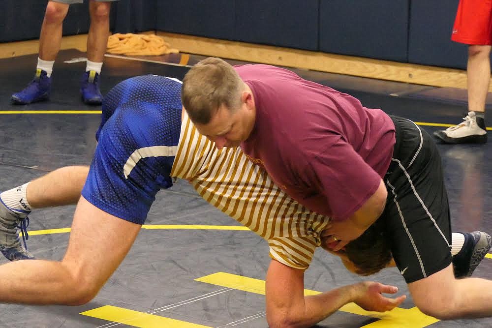 Thompson Falls wrestling coach Shane Thilmony (red shirt) works with a wrestler during a recent practice. (Chuck Bandel/Valley Press)