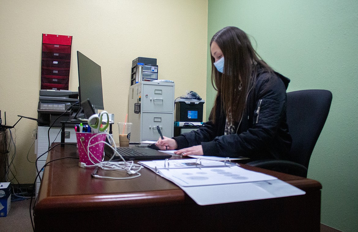 Lexi Smith, new executive director with the Downtown Moses Lake Association, works behind her desk on just her second day in the position on Tuesday, Dec. 29.