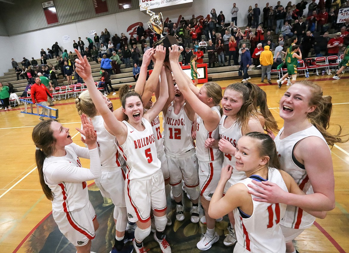 The Sandpoint girls basketball team celebrates with the district championship trophy after taking down Lakeland on Feb. 14, 2020.