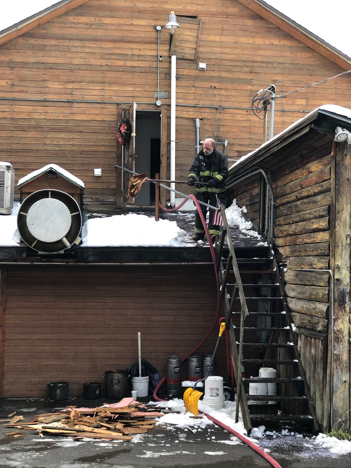 Mike North with Shoshone County Fire District No. 2 dumps a shovel's worth of debris from a small chimney fire that broke out inside the Snake Pit on New Year's Day. The fire was quickly put out and should only require a few days closure to repair some light damage.