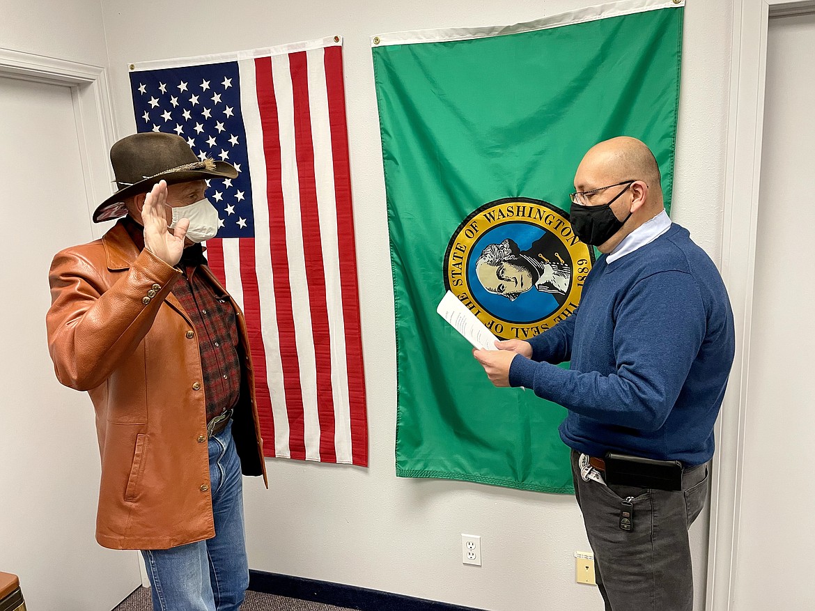 Grant County Superior Court Judge David Estudillo, right, swears in Rep. Tom Dent, R-Moses Lake, for a fourth term in the state legislature on Tuesday. Dent was sworn in at a small , private ceremony because the entire legislature will not be meeting physically in Olympia on Monday, Jan. 11, where newly elected and re-elected members are typically all sworn in together.