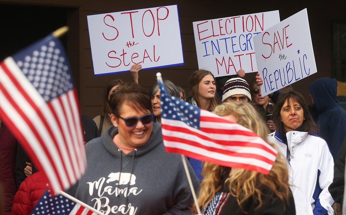 People hold flags and signs at Tuesday's rally in Coeur d'Alene