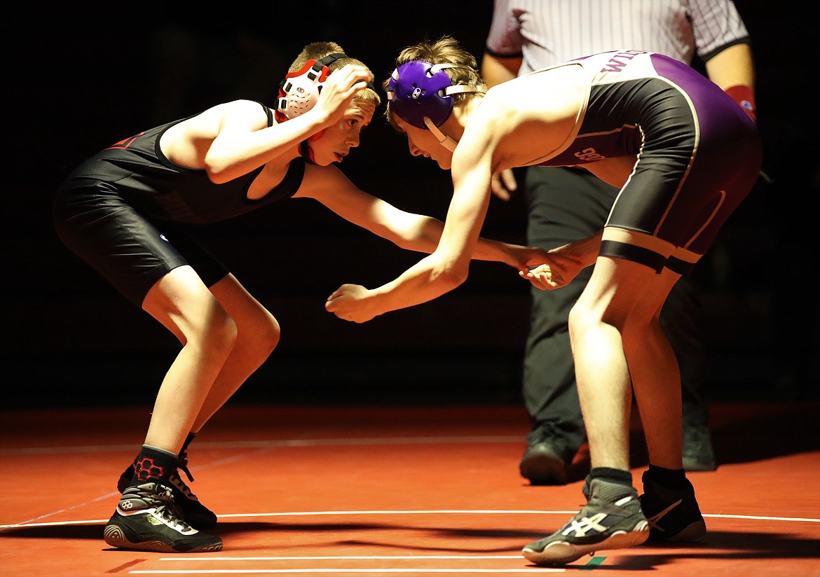Sandpoint's Andrew Duke (left) faces off with Kellogg's Chase Morden during a 98-pound match on Wednesday.
