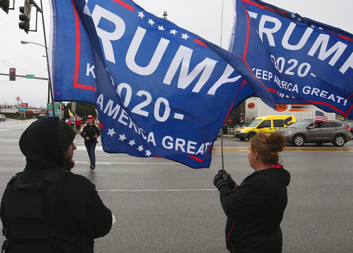 Austin Brady and Tammy Brady hold Trump banners on Wednesday.