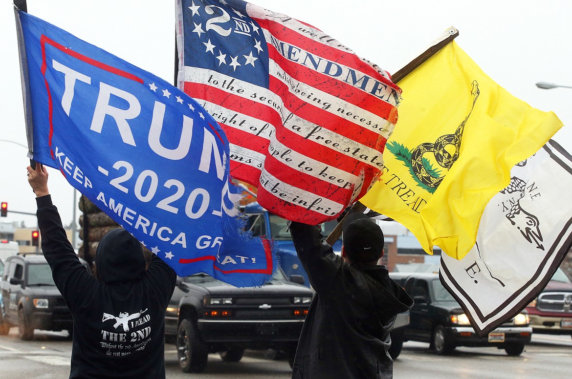 A few of the protesters at Wednesday's rally wave flag at the corner of U.S. 95 and Appleway Ave.