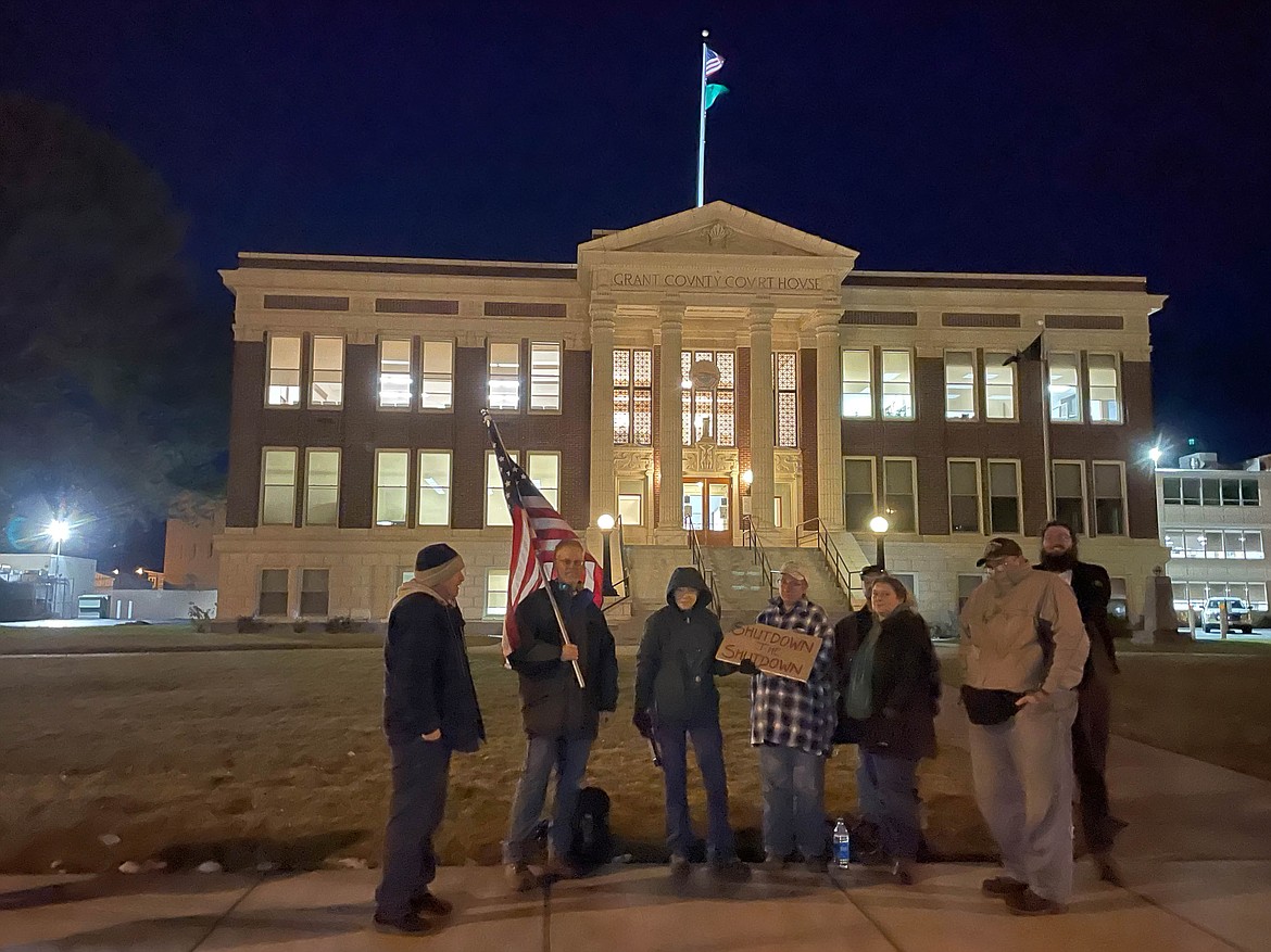 Dani Bolyard (hooded in the center) stands with fellow protesters in front of the Grant County Courthouse.
