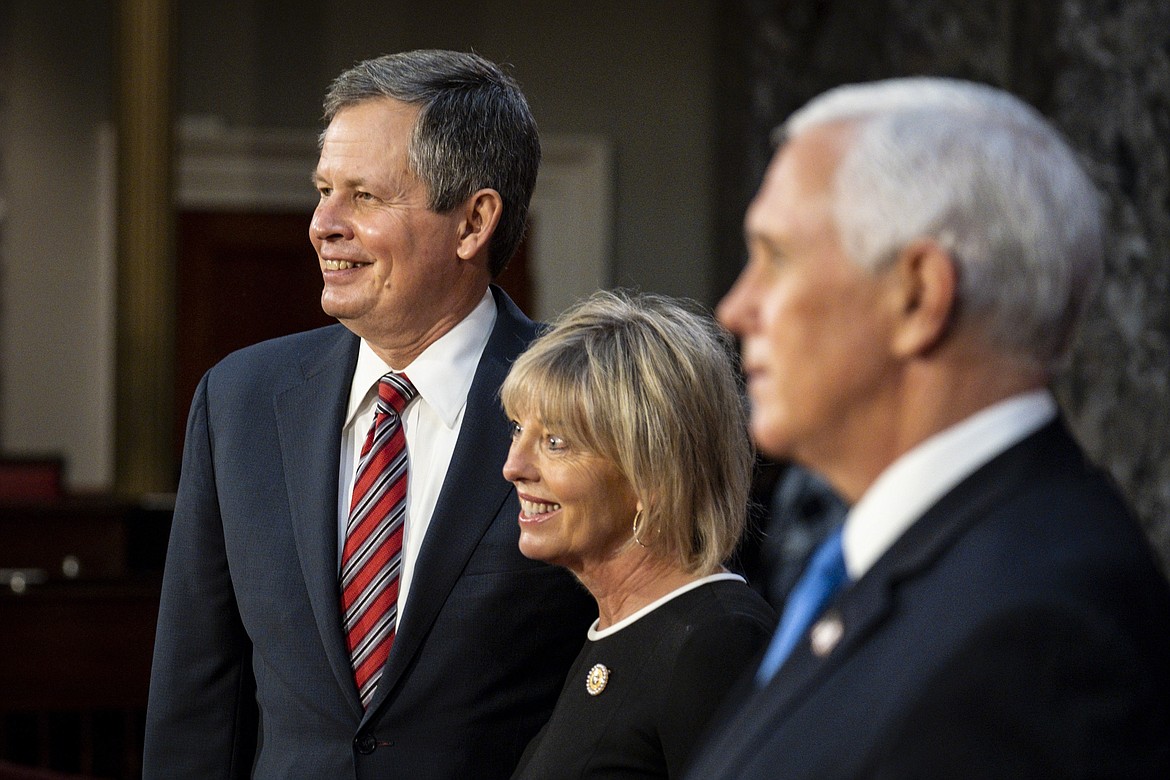 Vice President Mike Pence poses for a photo with Sen. Steve Daines, R-Mont., and his wife Cindy Daines in the Old Senate Chamber at the Capitol in Washington, Sunday, Jan. 3, 2021. (Pete Marovich/The New York Times via AP, Pool)