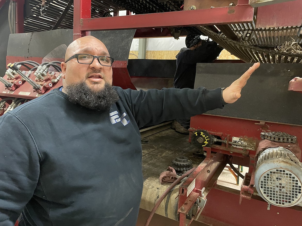 David Garza, the operations manager of Flamingo Trucker, shows how the company's custom eliminator works as Adrian Villareal works to keep the machine repairs.