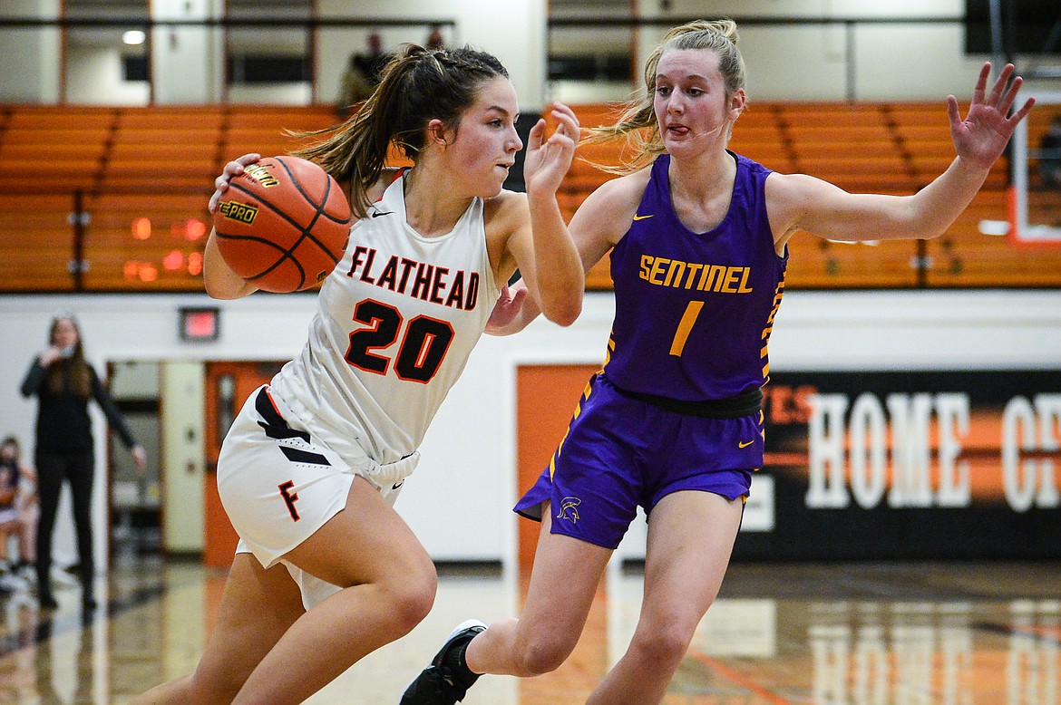 Flathead's Bridget Crowley (20) drives to the basket against Missoula Sentinel's Olivia Huntsinger (1) in the third quarter at Flathead High School on Thursday. (Casey Kreider/Daily Inter Lake)