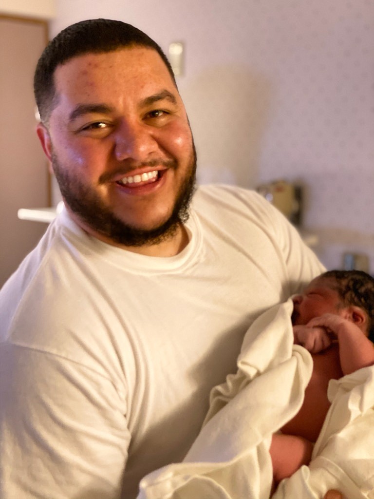 Matt Adame holds his newborn son, Romeo.