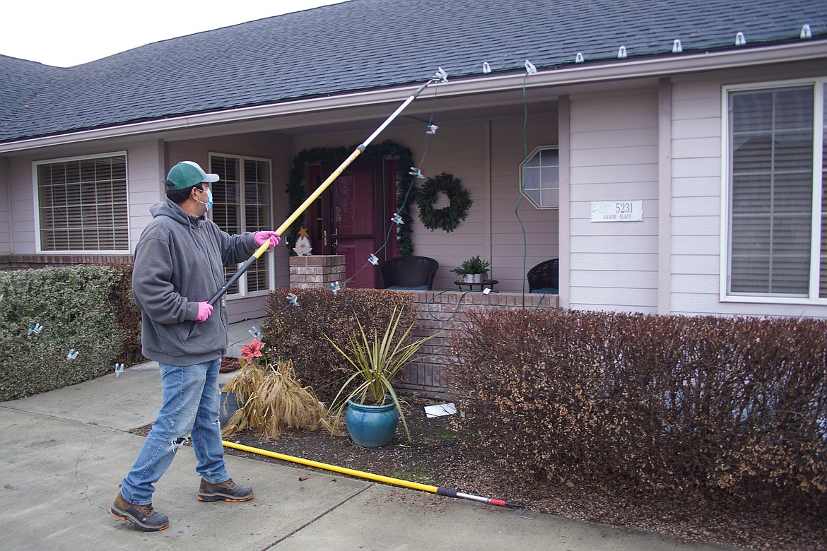 Rene Ramirez of Tatum Lawn Care takes down lights after the holidays.