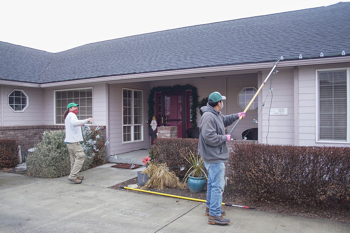 Rene Ramirez and James Allen of Tatum Lawn Care take down lights after the holidays.