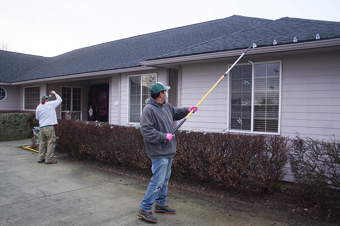 Rene Ramirez of Tatum Lawn Care takes down lights after the holidays.