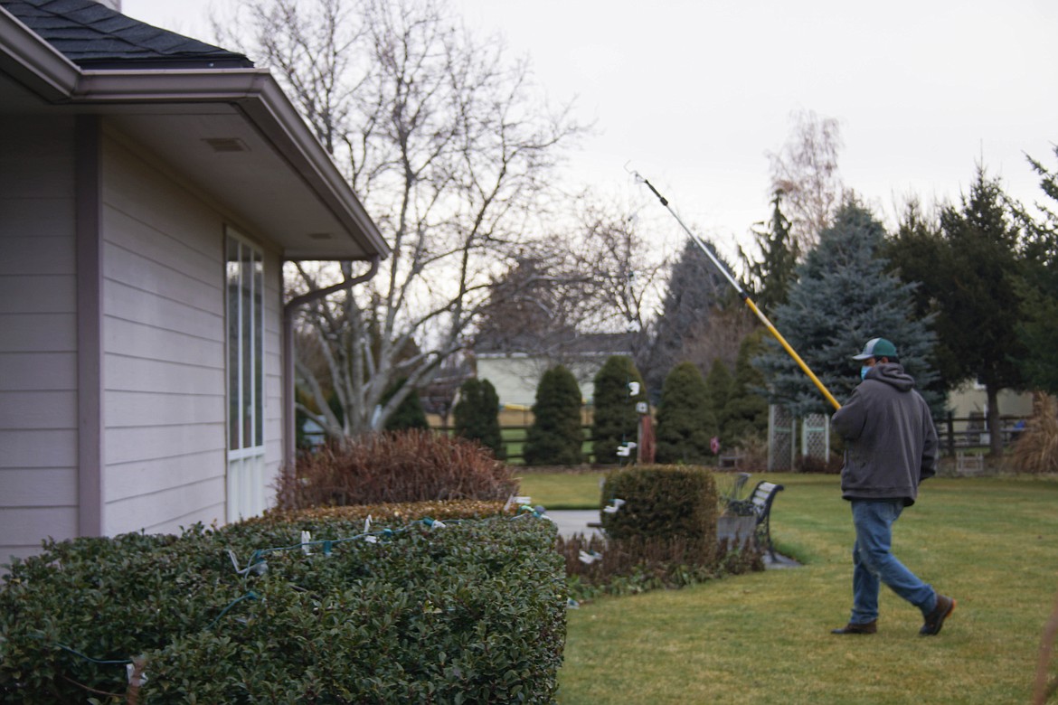 Rene Ramirez of Tatum Lawn Care takes down lights after the holidays.