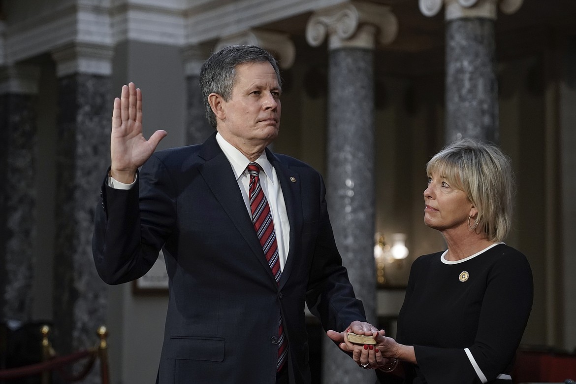 FILE - In this Jan. 3, 2021, file photo, Sen. Steve Daines, R-Mont., joined by his wife Cindy Daines, raises his hand to take the oath of office from Vice President Mike Pence during a reenactment ceremony in the Old Senate Chamber at the Capitol in Washington. After months of tacitly or directly supporting President Donald Trump's denial of the results of the 2020 election, top Montana Republicans denounced the violence that took over the nation's Capitol and delayed Congress' certification of the presidential election for Joe Biden. But one of them doubled down. (AP Photo/J. Scott Applewhite, Pool, File)