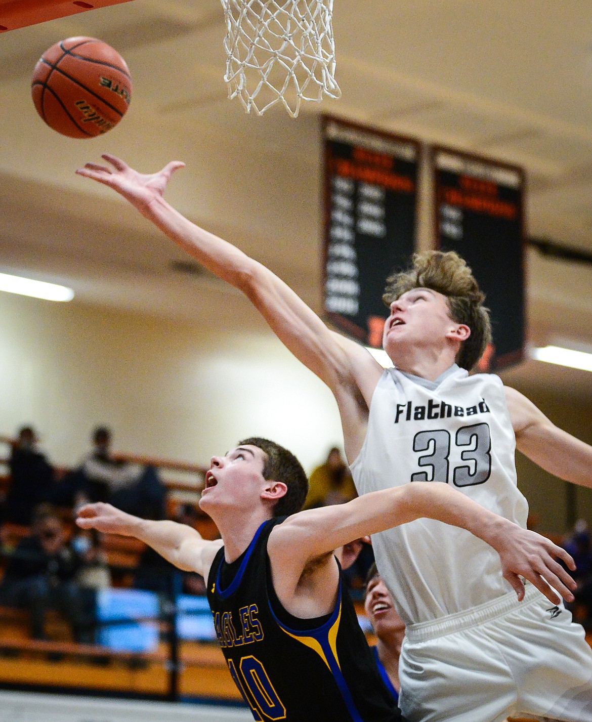 Flathead's Ezra Epperly (33) reaches for a rebound over Missoula Big Sky's Caden Bateman (10) in the second half at Flathead High School on Saturday. (Casey Kreider/Daily Inter Lake)