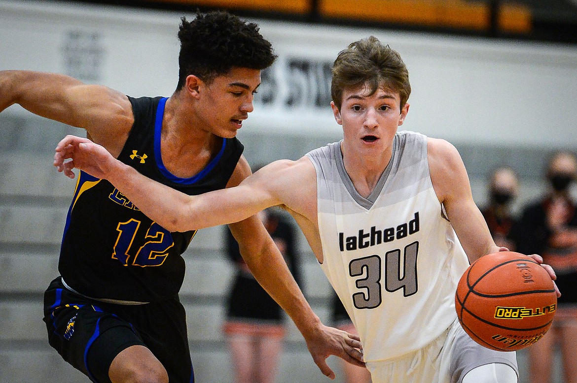 Flathead's Joston Cripe (34) heads to the hoop past Missoula Big Sky's Louis Sanders (12) in the first quarter at Flathead High School on Saturday. (Casey Kreider/Daily Inter Lake)