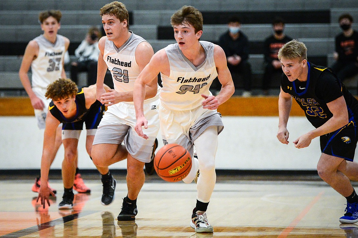 Flathead's Joston Cripe (34) scoops up a loose ball and leads a fast break in the first half against Missoula Big Sky at Flathead High School on Saturday. (Casey Kreider/Daily Inter Lake)