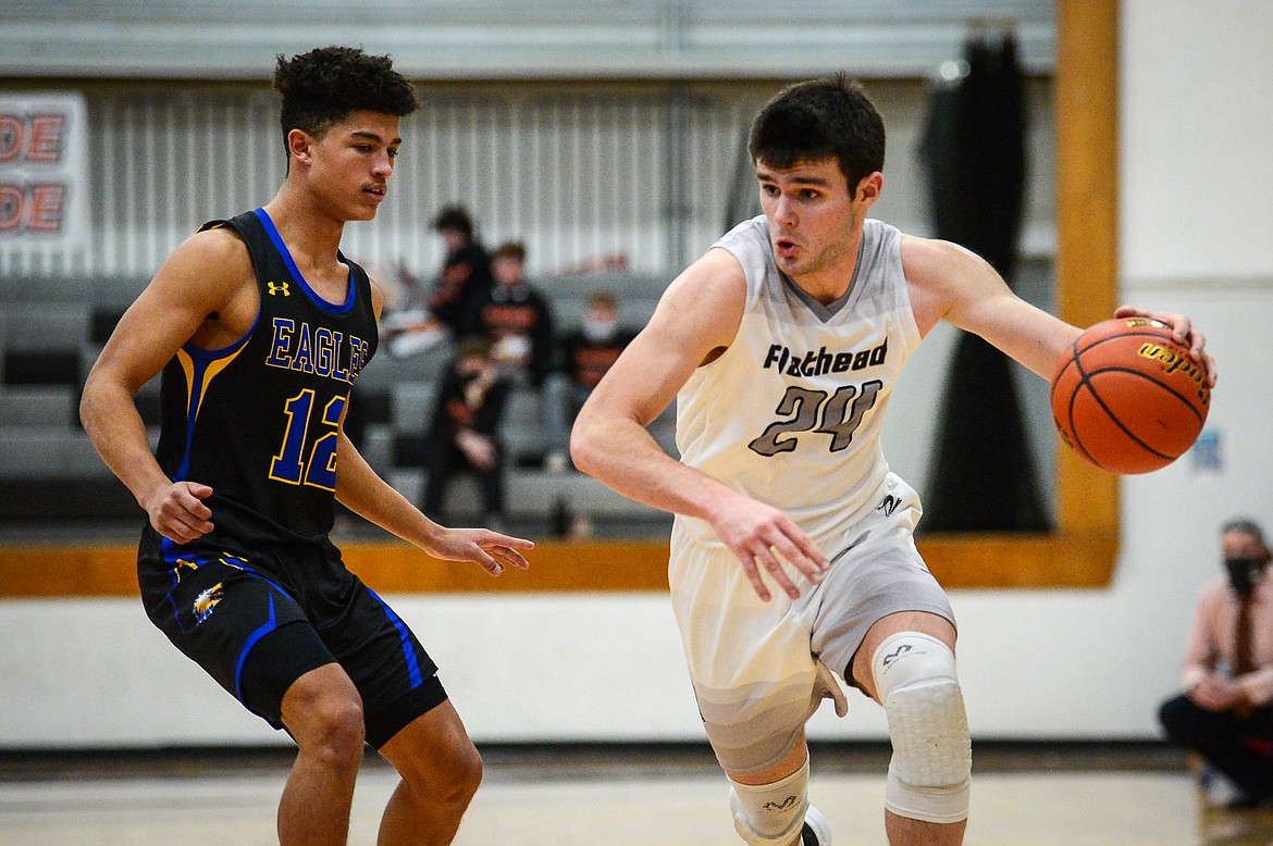 Flathead's Gabe Adams (24) tries to dribble past Missoula Big Sky's Louis Sanders (12) in the first half at Flathead High School on Saturday. (Casey Kreider/Daily Inter Lake)