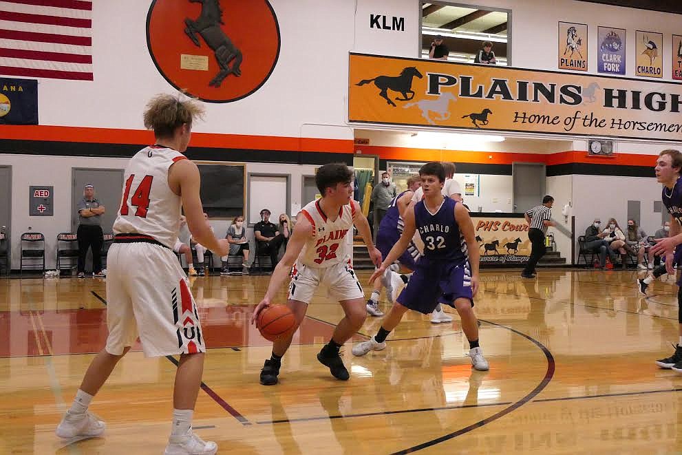 Plains’ Nathan Feliksa is guarded by Charlo's Nathan Clark during last week’s game.  (Chuck Bandel/Valley Press)