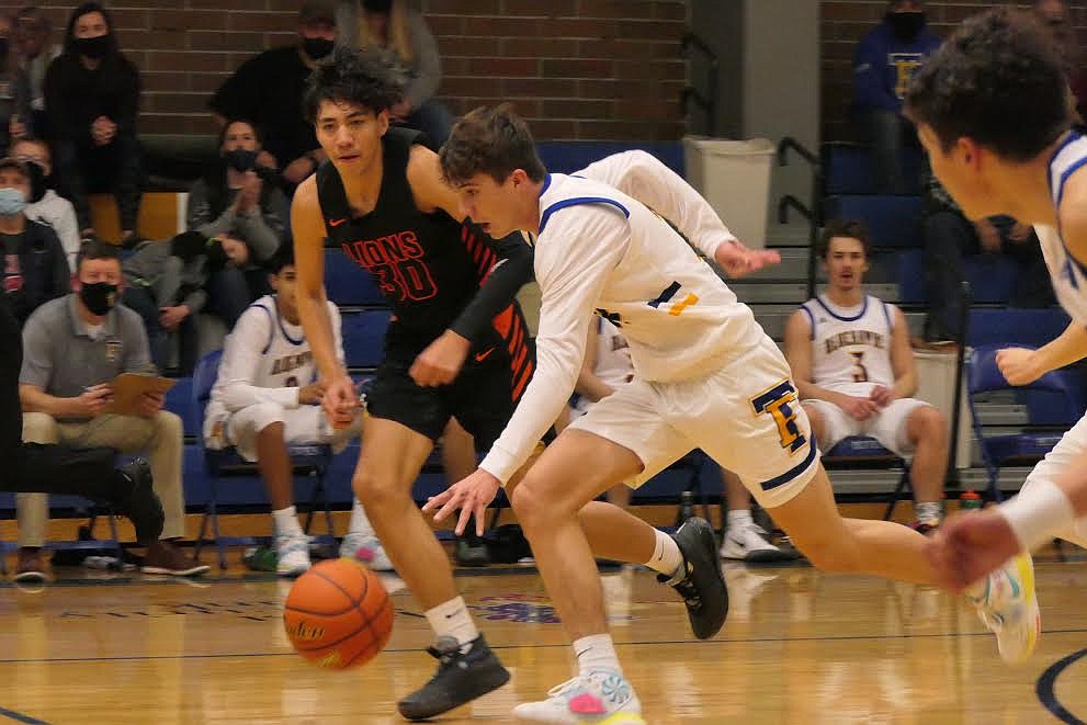 Thompson Falls forward Kade Pardee dribbles past Matt Spoonhunter of Eureka during the game Saturday night. (Chuck Bandel/Valley Press)