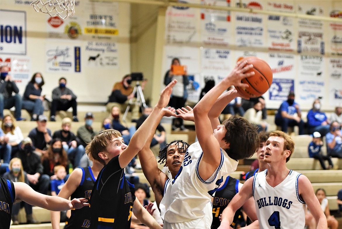 Zoran LaFrombois puts up a shot in a crowd, as Thompson Falls' Justin Morgan defends, in front of Bulldogs Layne Spidel (4) and Javon Bolen. (Scot Heisel/Lake County Leader)