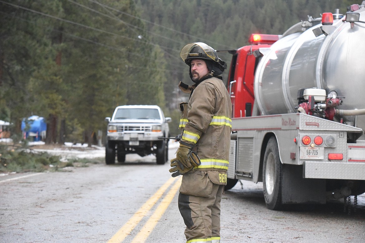 Libby Volunteer Fireman Neil Benson directs cars around a drooping power line on Kootenai River Road. Heavy winds downed power lines and trees on Jan. 13 throughout Lincoln and Flathead counties.