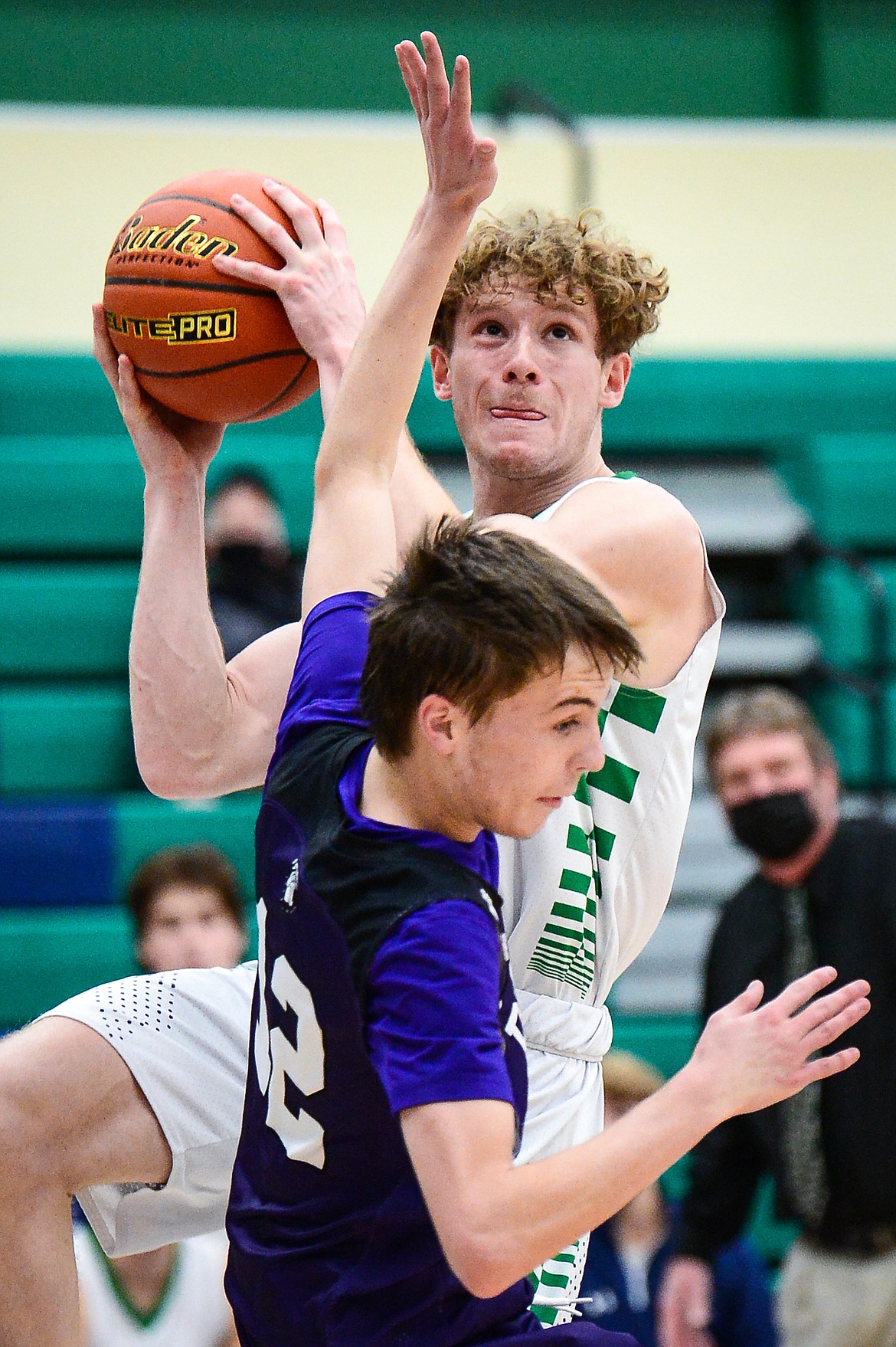 Glacier's Colin Presnell (32) draws a foul on his way to the basket against Butte's Billy Kelly (12) in the third quarter at Glacier High School on Thursday. (Casey Kreider/Daily Inter Lake)