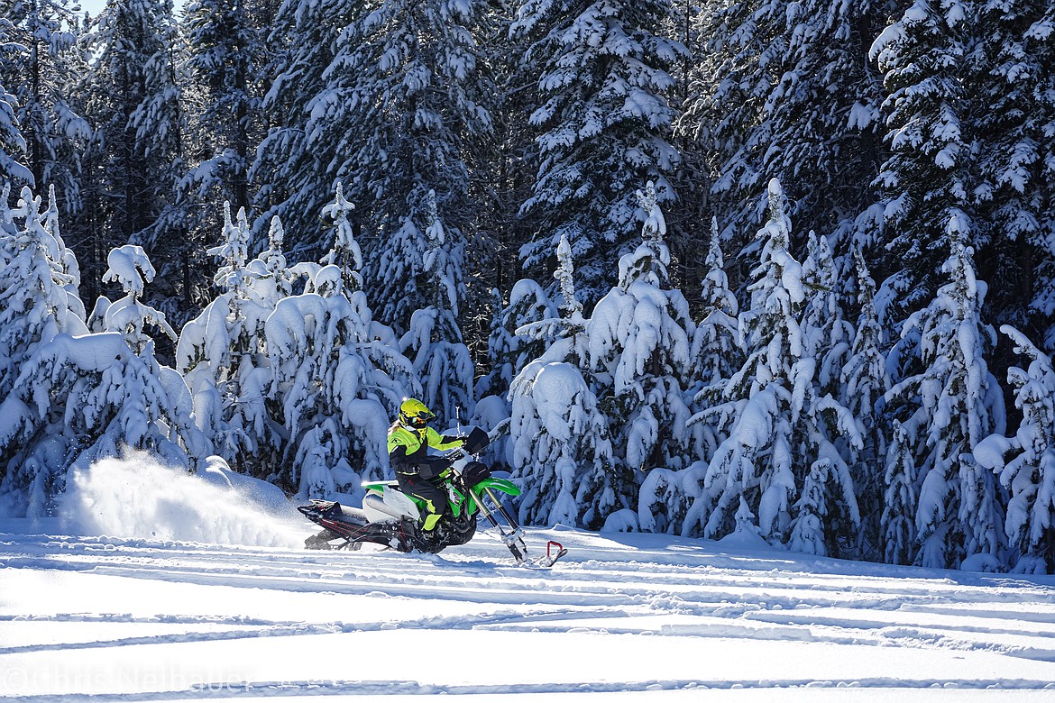 A snow bike rider coasts through an open field.