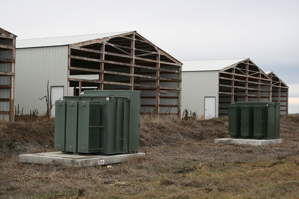 A cryptocurrency facility sits unused, with electrical transformers outside, at the intersection of Road 1 SE and Road L.4 SE. Grant County PUD commissioners are involved in a continuing discussion about electrical rates for cryptocurrency operations.