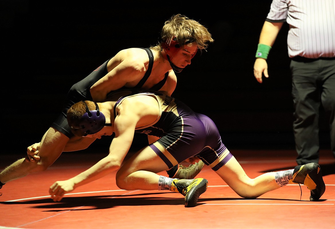 Sandpoint's Tanner Dickson (left) takes on Kellogg's Raymond Heely in a 120-pound match on Jan. 6 at Les Rogers Court.