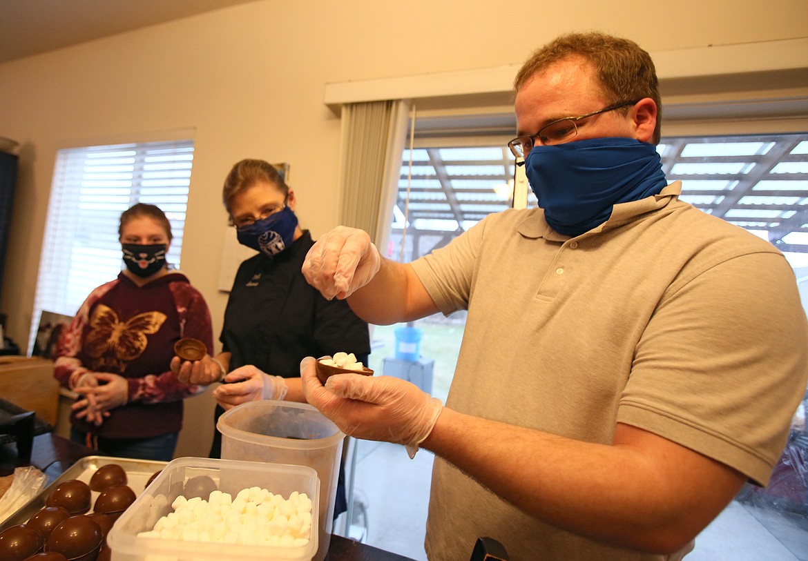 Andrew Shiley, 32, of Coeur d'Alene, carefully fills a chocolate cocoa bomb with miniature marshmallows Thursday evening in Village Bakery owner chef Dana Bellefeuille's Coeur d'Alene kitchen, which doubles as her business. She is in the process of finding a brick-and-mortar location for the bakery, which runs on volunteers to provide experience and opportunities for people with special needs and disabilities.