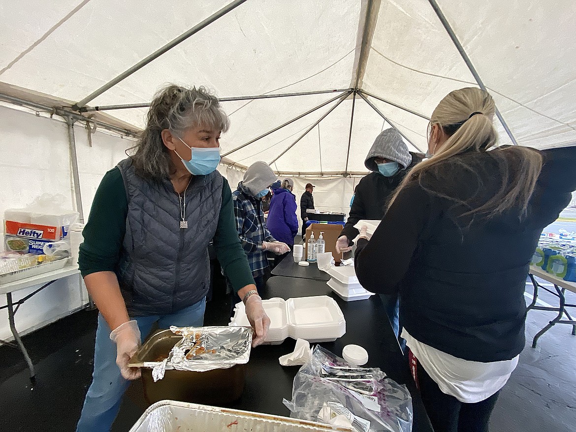 Volunteers with Candlelight Christian Fellowship church pass out pulled pork and beef brisket sandwiches, coleslaw, mac and cheese, and smoked baked beans to first responders Friday afternoon. (MADISON HARDY/Press)