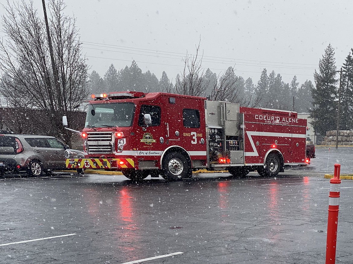 Showing their thanks for Candlelight Christian Fellowship's warm meal, the Coeur d'Alene Fire Department blares their horn and lights after leaving the food giveaway Friday afternoon. (MADISON HARDY/Press)