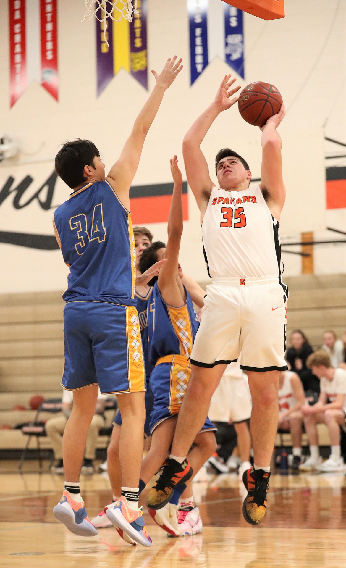 Sophomore Jace Yount attempts to knock down a shot over a pair of North Idaho Christian defenders during a game on Jan. 4 at PRLHS.