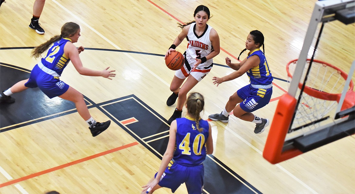 LaReina Cordova (5) drives to the hoop as a trio of Libby defenders descends. (Scot Heisel/Lake County Leader)