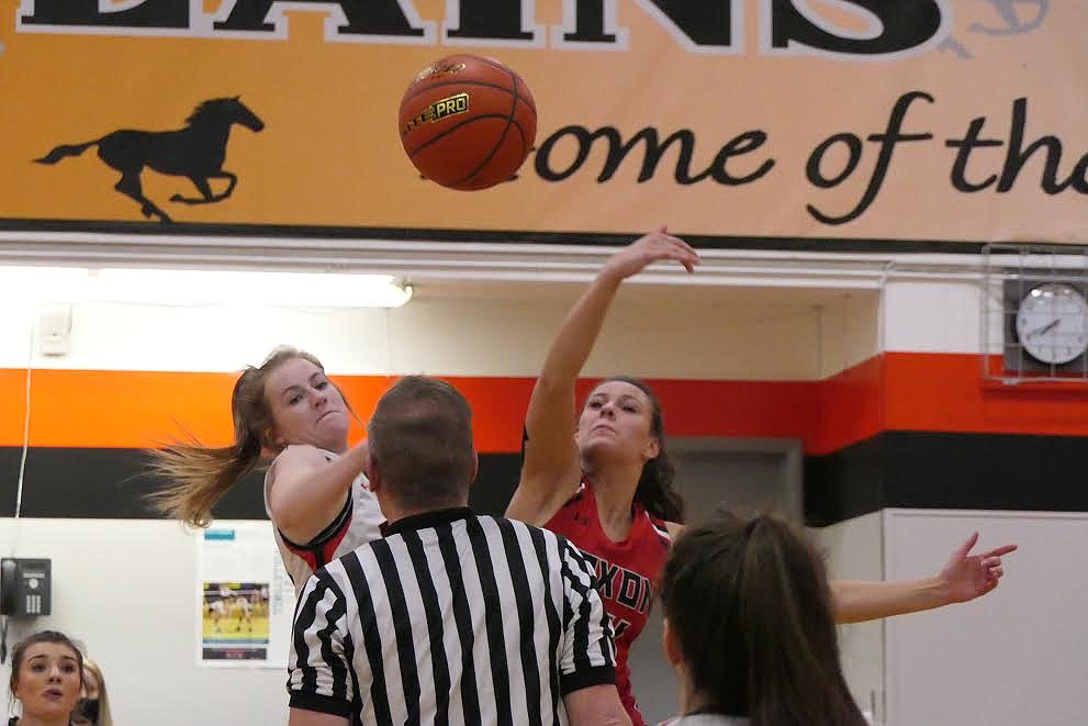 Noxon sophomore standout Avery Burgess fights for the opening tip with Plains sophomore Kimmy Curry Friday night in Plains. (Chuck Bandel/Valley Press)