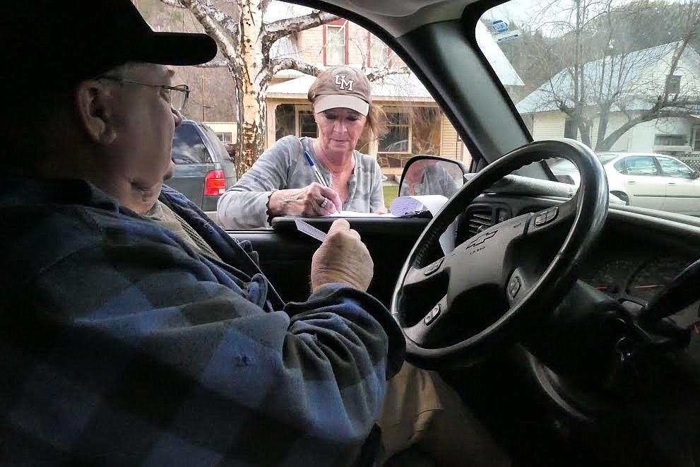 Terry Campbell gives a simple ballot about the proposed sewage project to protest organizer Lee Ann Overman, a Paradise resident. (Chuck Bandel/Valley Press)